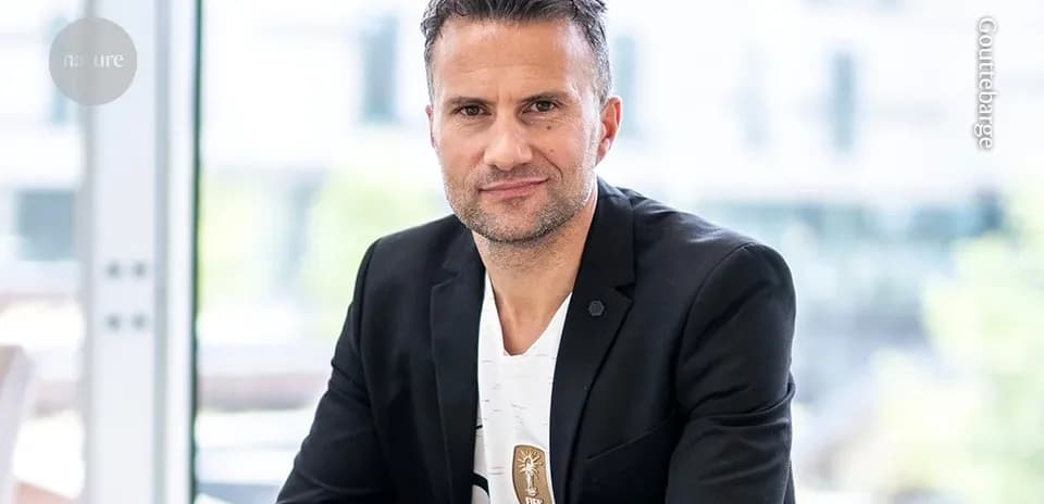 Man in a black blazer sitting indoors