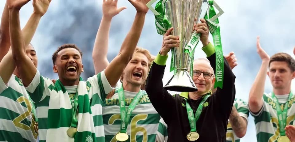 Team celebrating trophy victory with manager holding cup