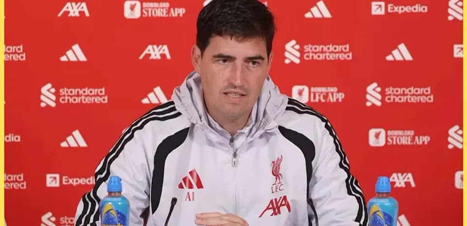 Manager speaking at press conference with sponsors' logos