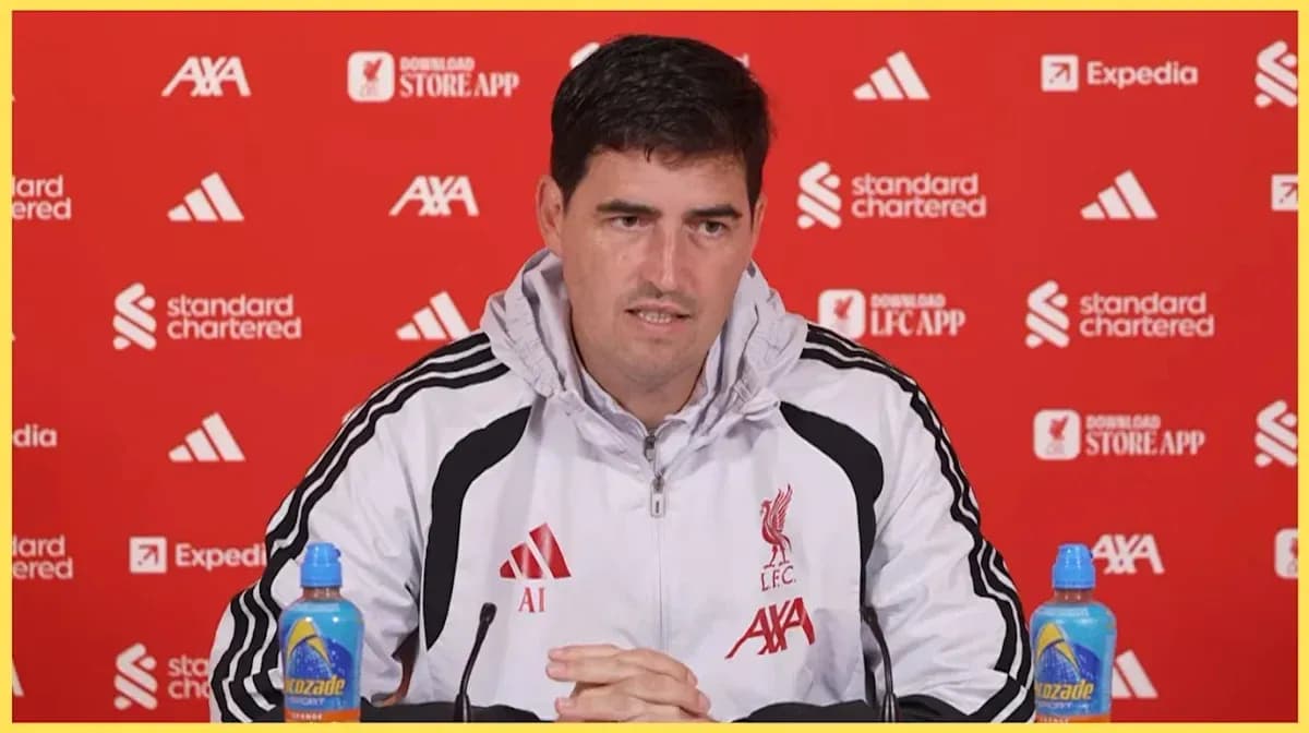 Manager speaking at press conference with sponsors' logos