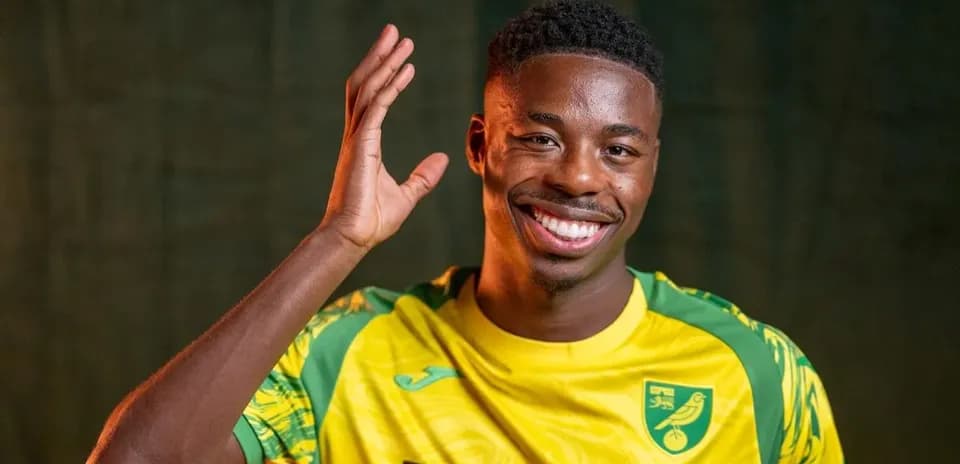 Player smiling and waving in team jersey