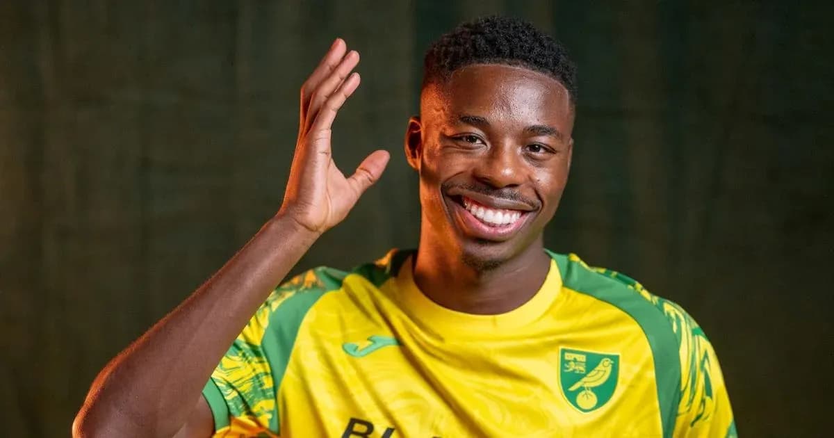 Player smiling and waving in team jersey