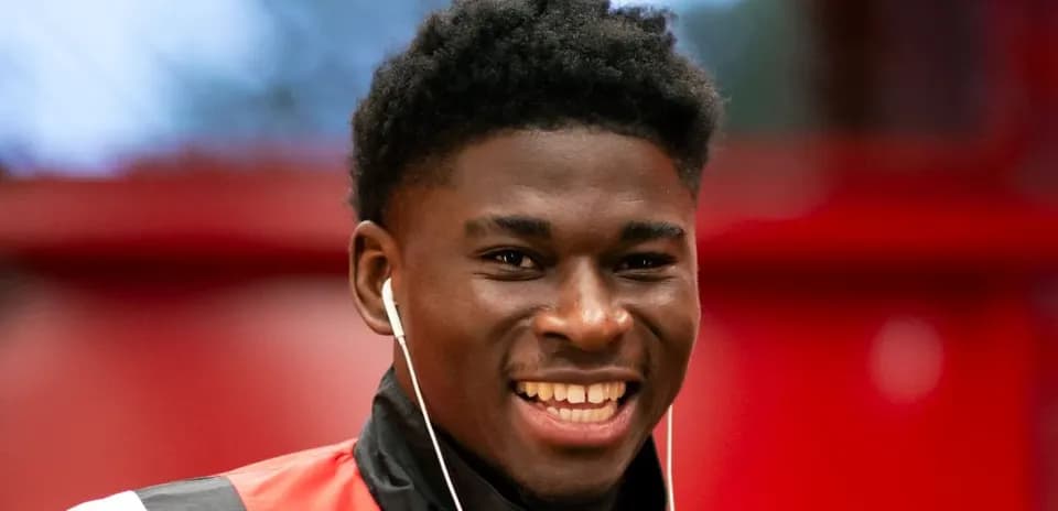 Player smiling while wearing earbuds indoors