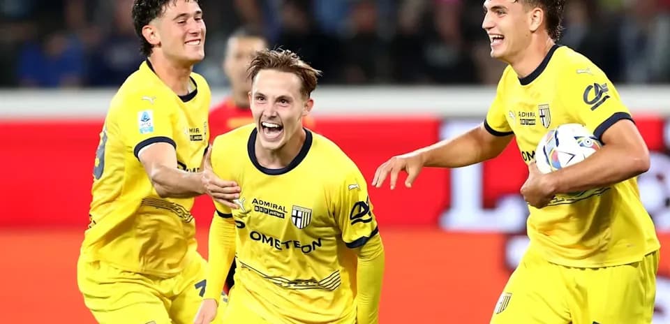 Three Parma players celebrating a goal together