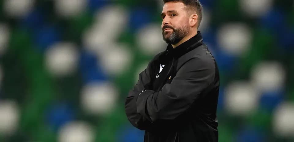Coach observing from the sidelines during match