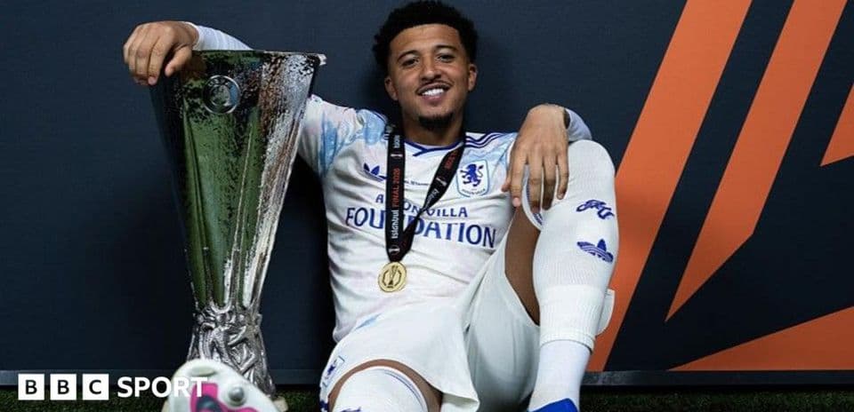 Player celebrating with UEFA trophy and medal