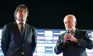 Two men at podium during press event