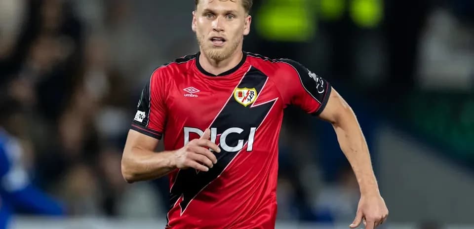 Player running in red football kit during match