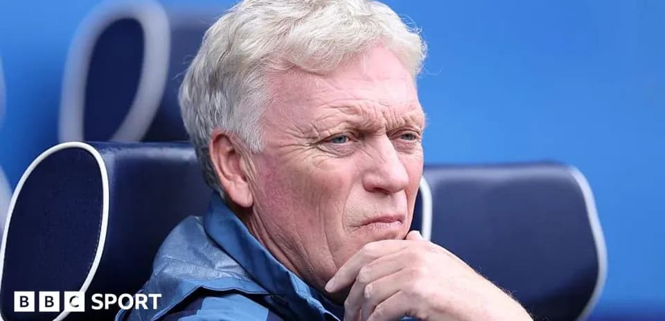 Manager seated on bench during match