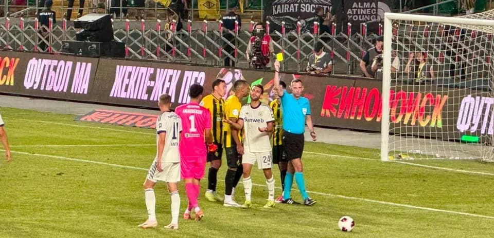 Players interacting with referee during Kairat match