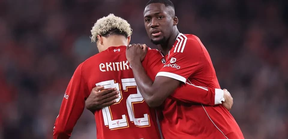 Two players in red jerseys embracing on field