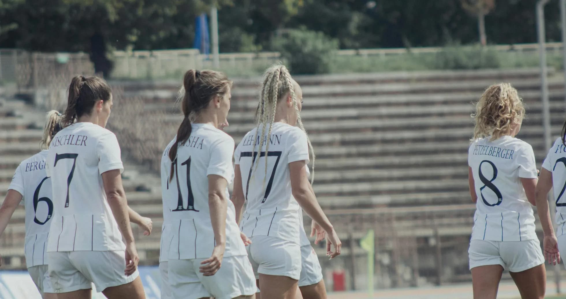 Players walking on the pitch in white uniforms