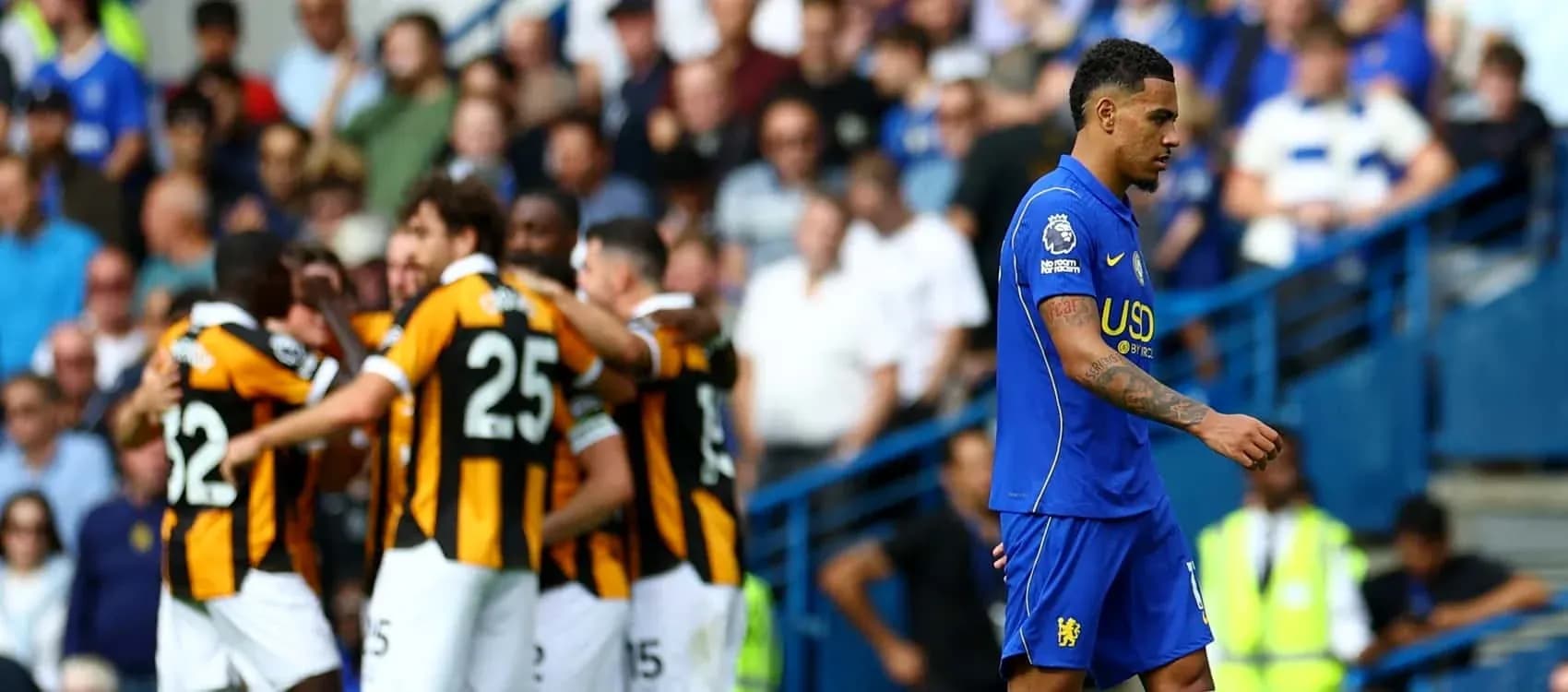Player walking away as teammates celebrate goal