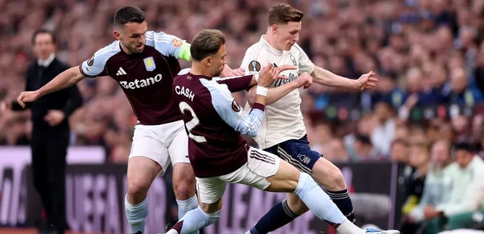 Two Aston Villa players tackling opponent during match