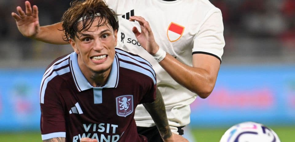 Aston Villa player being challenged by opponent