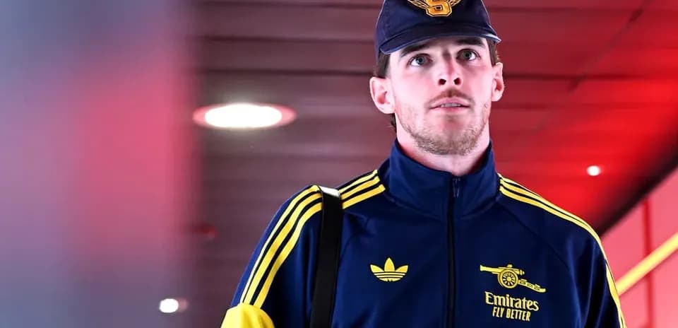 Player walking through airport terminal in team tracksuit