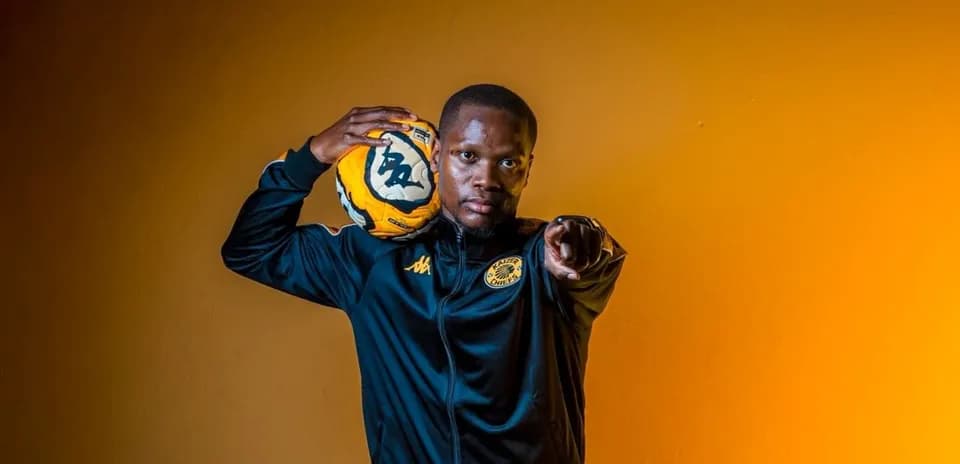 Player posing with soccer ball against orange background