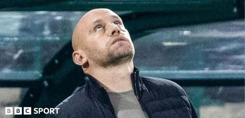 Coach looking up from the dugout during match