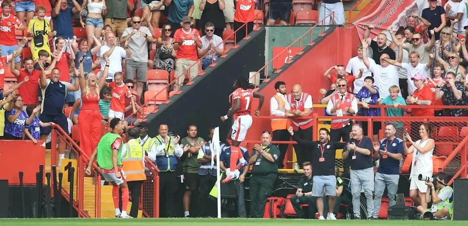 Players celebrating with enthusiastic fans in stadium