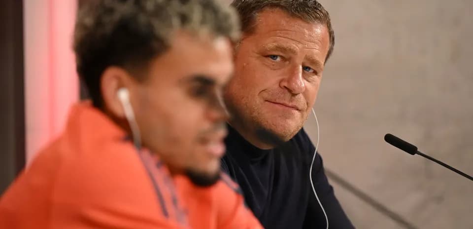 Two men seated at press conference table
