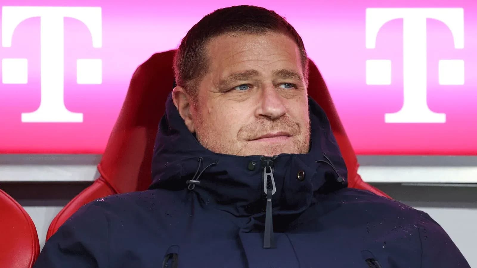 Coach seated on bench during match