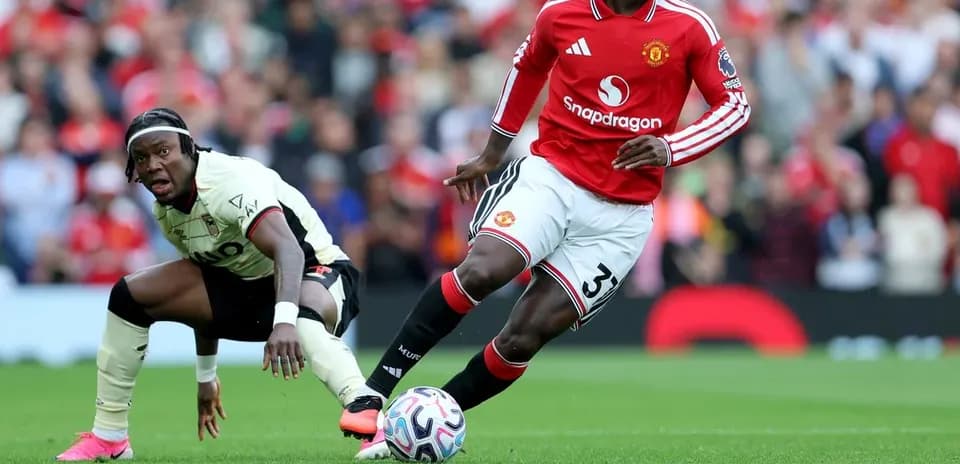 Manchester United player dribbling past opponent on field