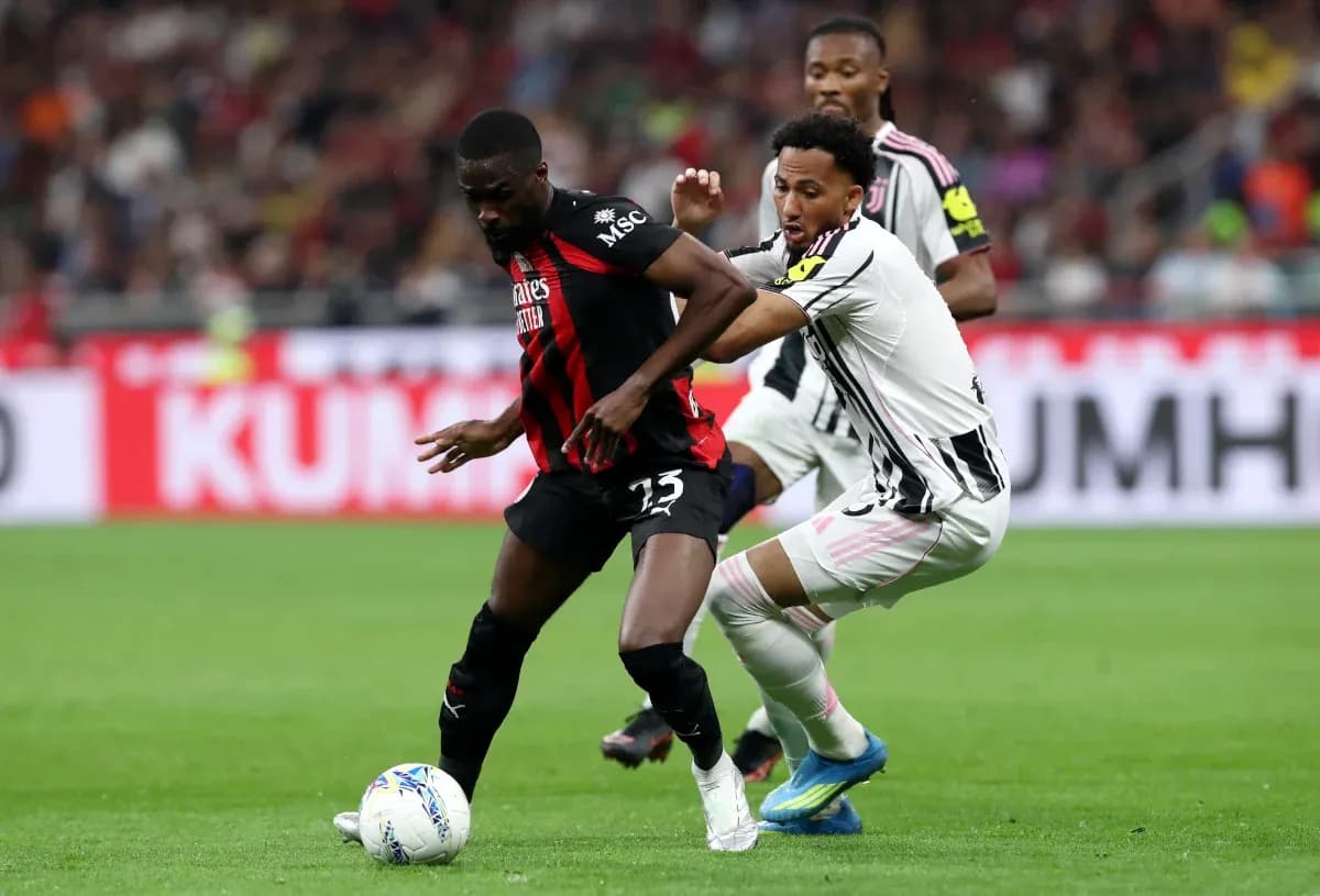 Juventus player tackling AC Milan opponent