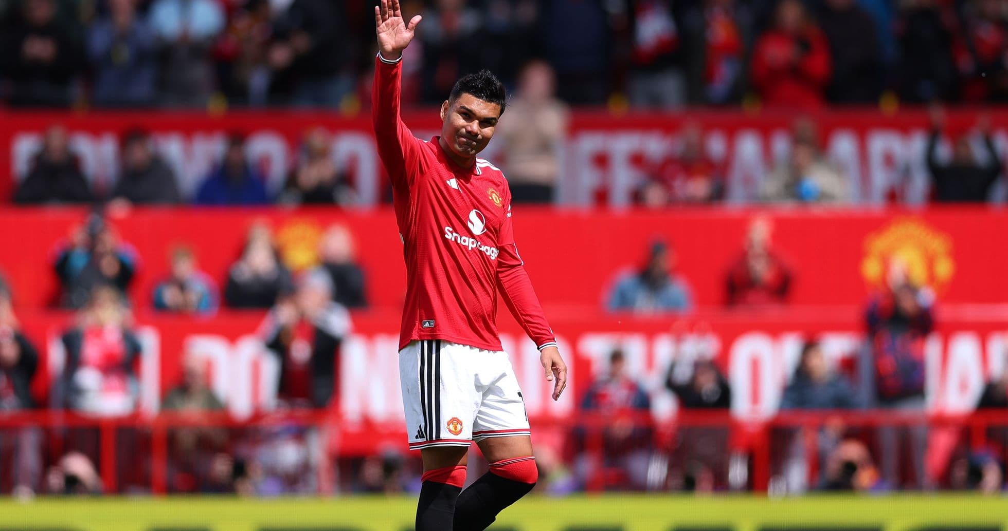Player waving to fans at Manchester United stadium