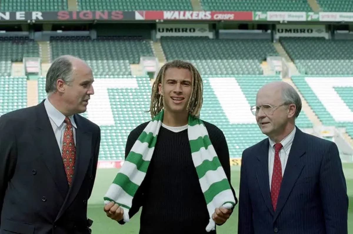 New player holding scarf with club officials at stadium