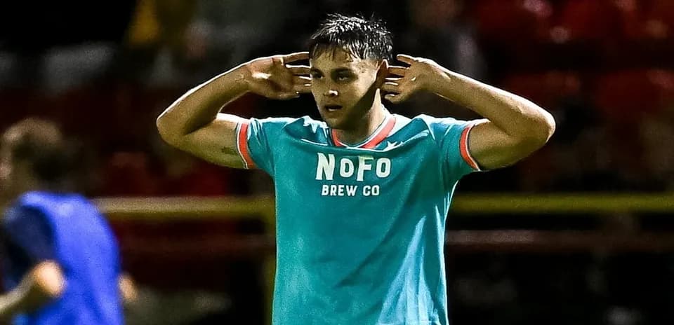 Player celebrating with hands to ears on field