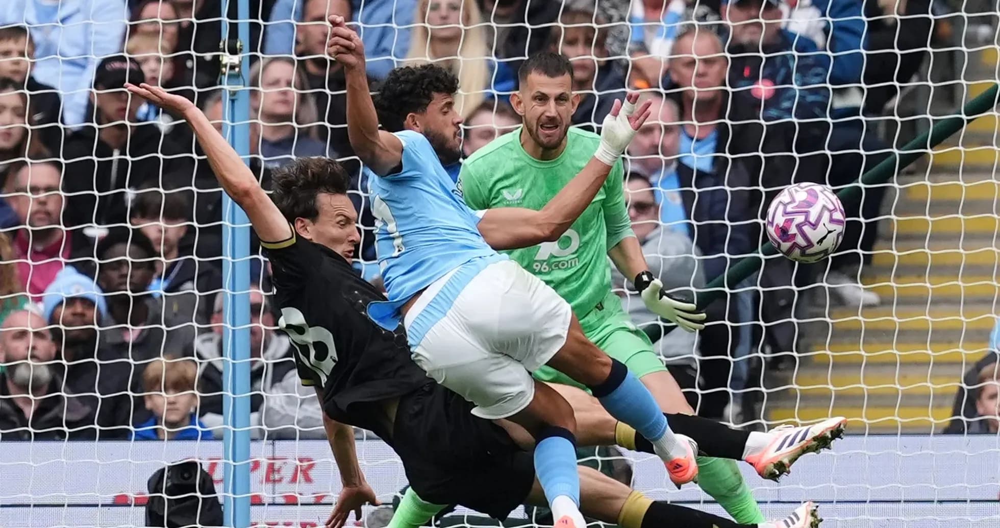 Goalkeeper and defenders contesting a shot on goal