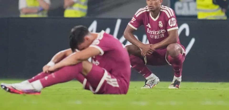 Real Madrid players seated on field after match