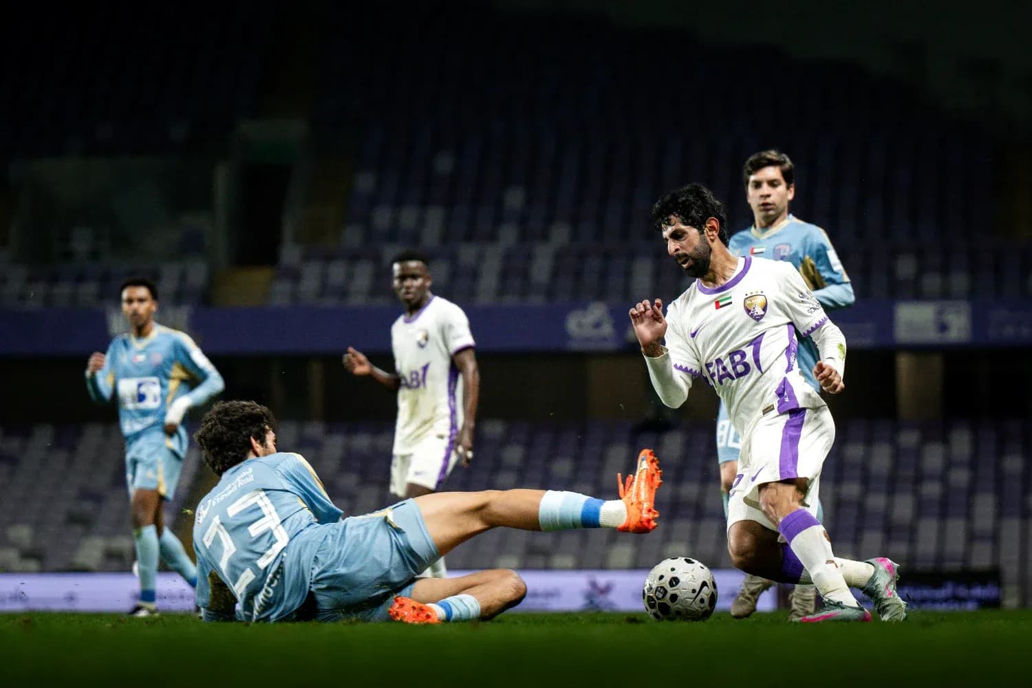 Player tackling opponent during Al Dhafra vs Al Ain match