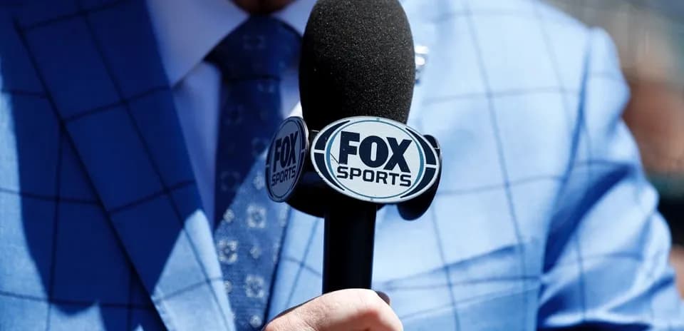 Microphone with FOX Sports logo held in hand