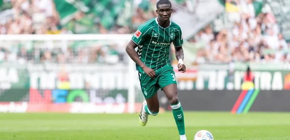 Player in green kit running on the pitch