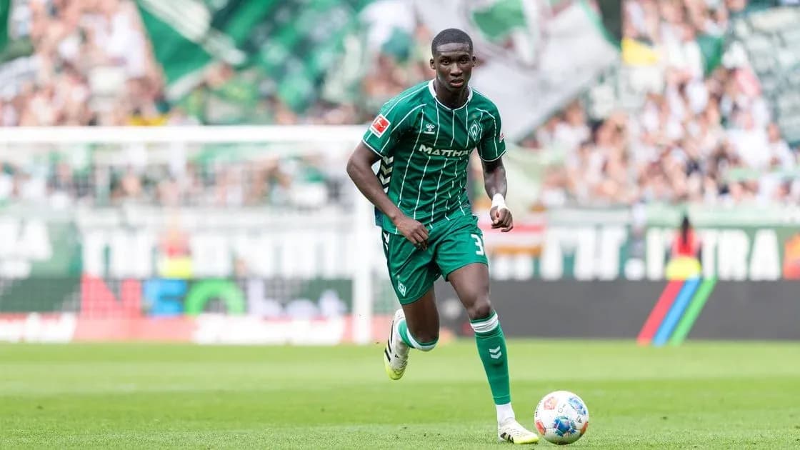 Player in green kit running on the pitch