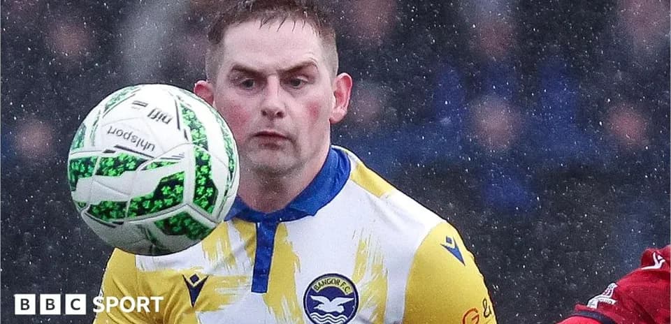 Player controlling ball during rainy football match