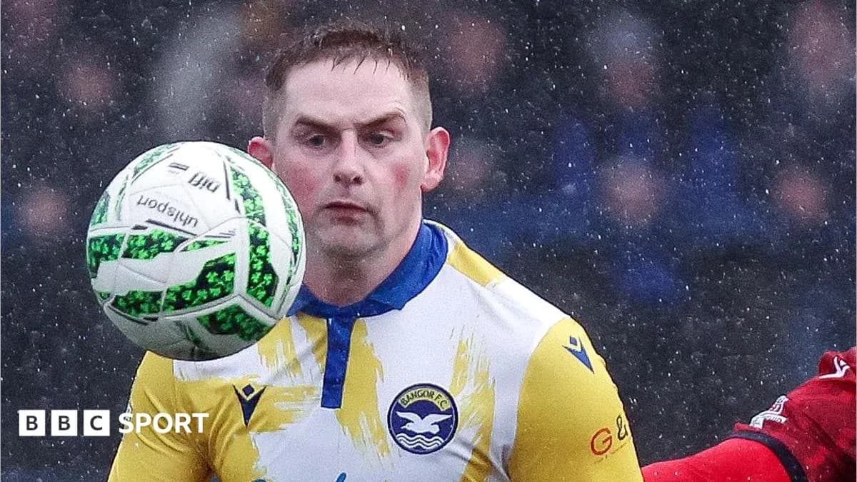 Player controlling ball during rainy football match