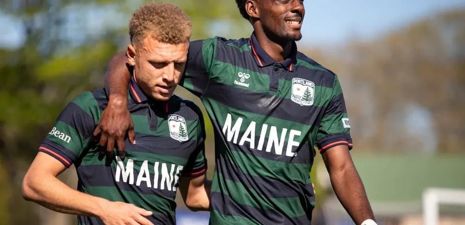 Two Portland players celebrating on the field