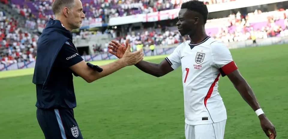 Coach and player shaking hands on the pitch