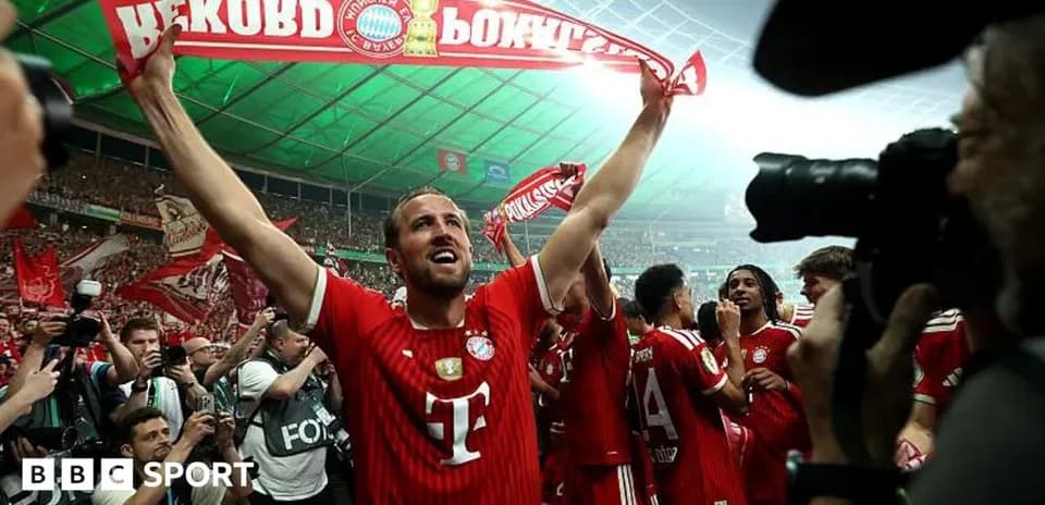 Player celebrating with Bayern Munich fans holding banner