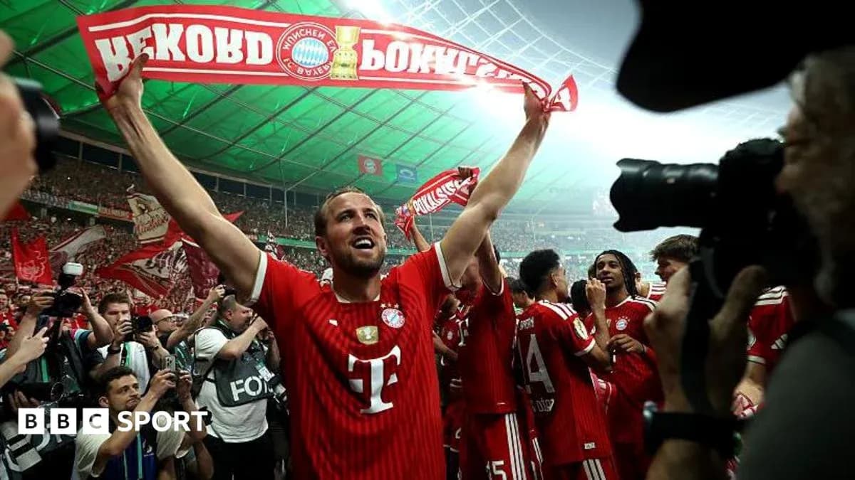 Player celebrating with Bayern Munich fans holding banner