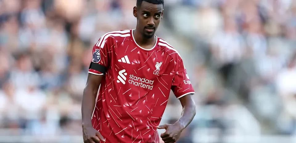 Player in Liverpool kit gesturing during match