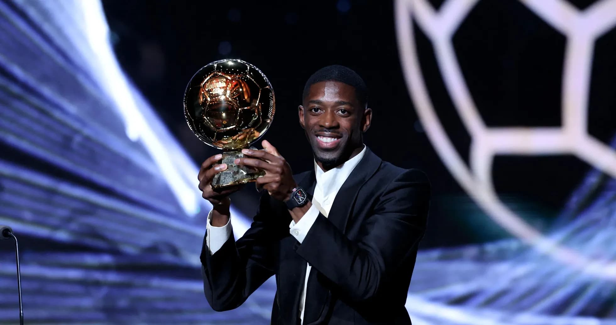 Player holding the Ballon d'Or trophy on stage