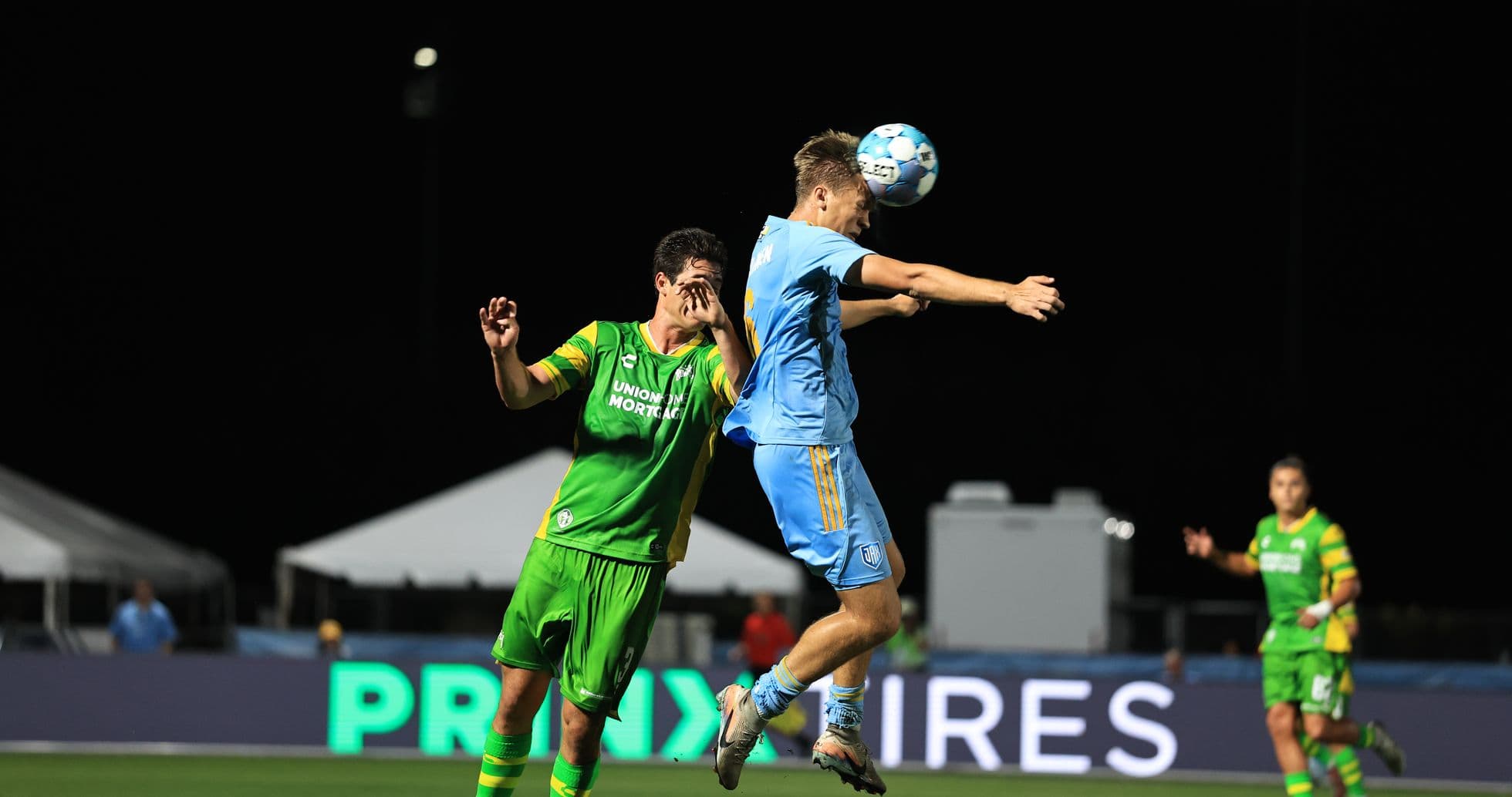 Player jumping to head the ball during match