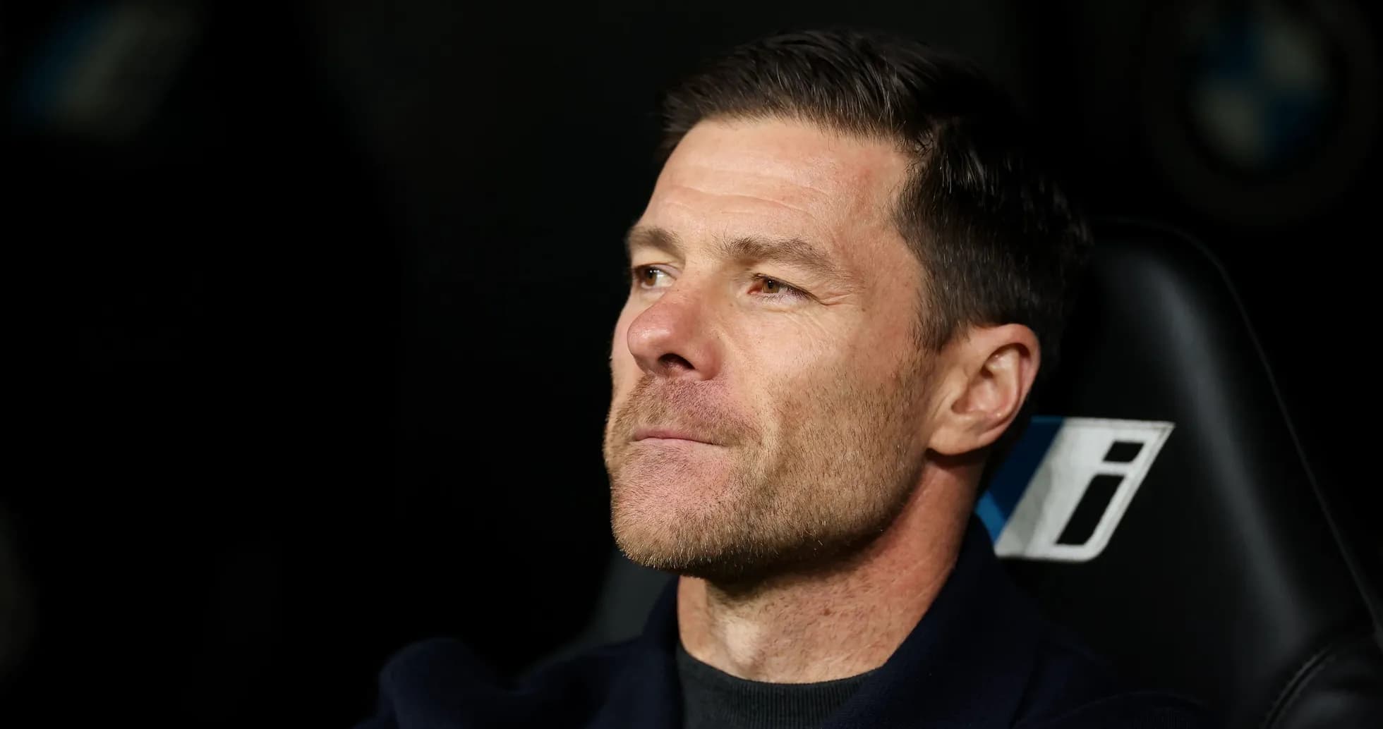 Coach seated on bench during match observation