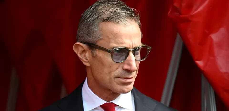 Man wearing glasses in front of red backdrop