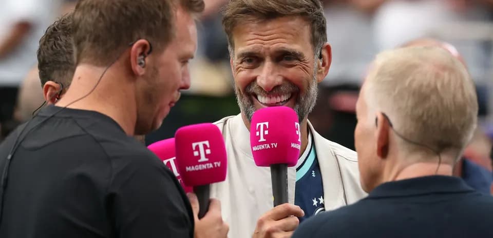 Three broadcasters holding microphones during an interview