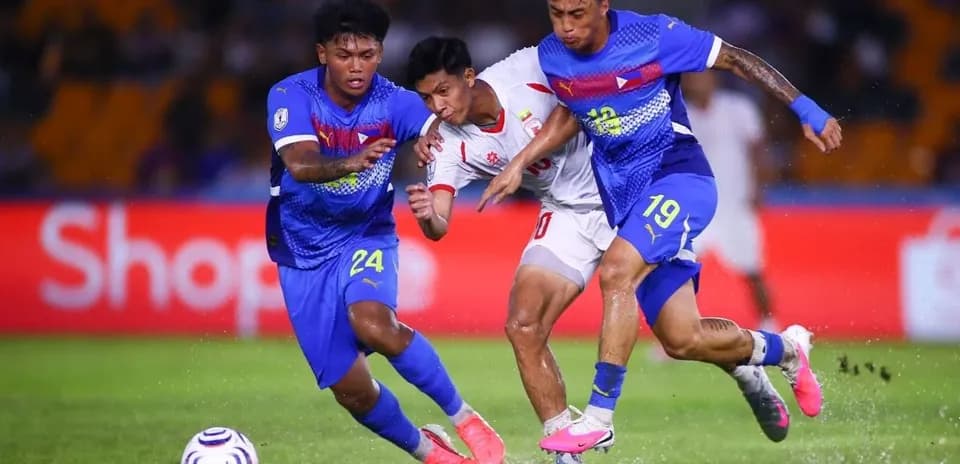 Two players tackling an opponent during a match