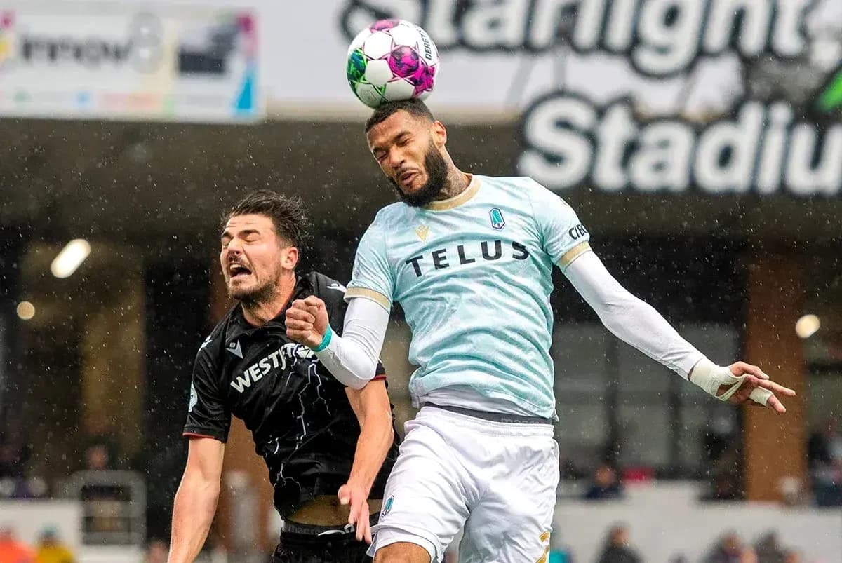 Pacific FC player heading the ball against Cavalry FC